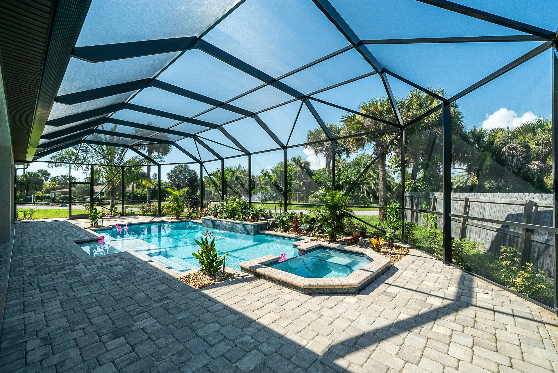 Panoramic screen enclosure over a geometric pool and raised spa