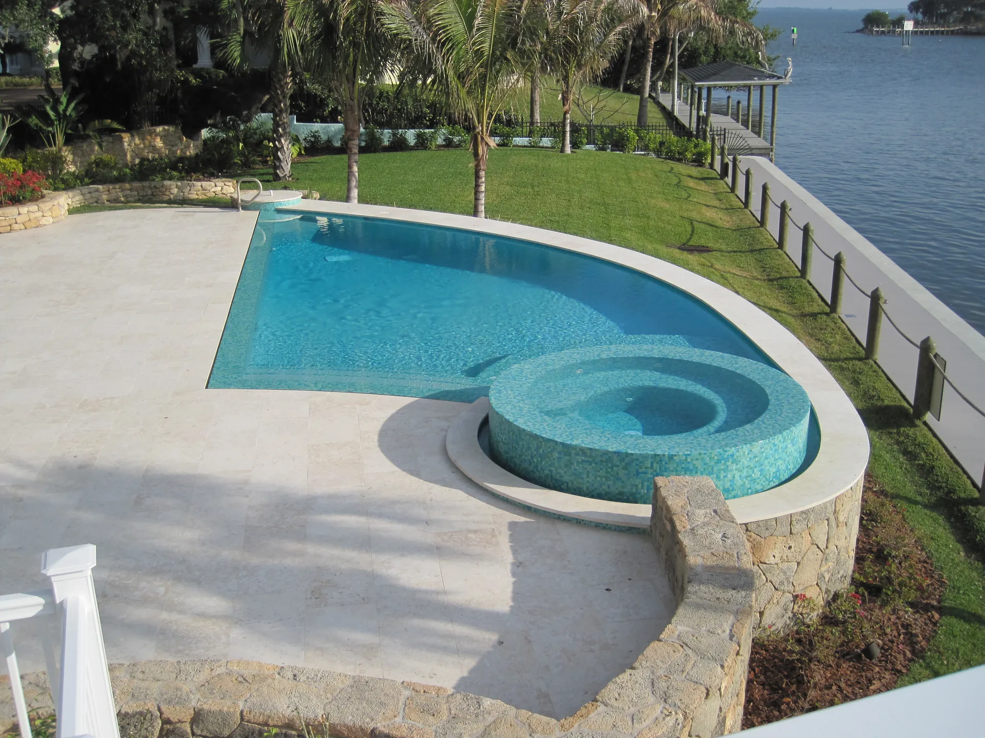 Raised glass tile spa on a travertine deck overlooking the Indian River