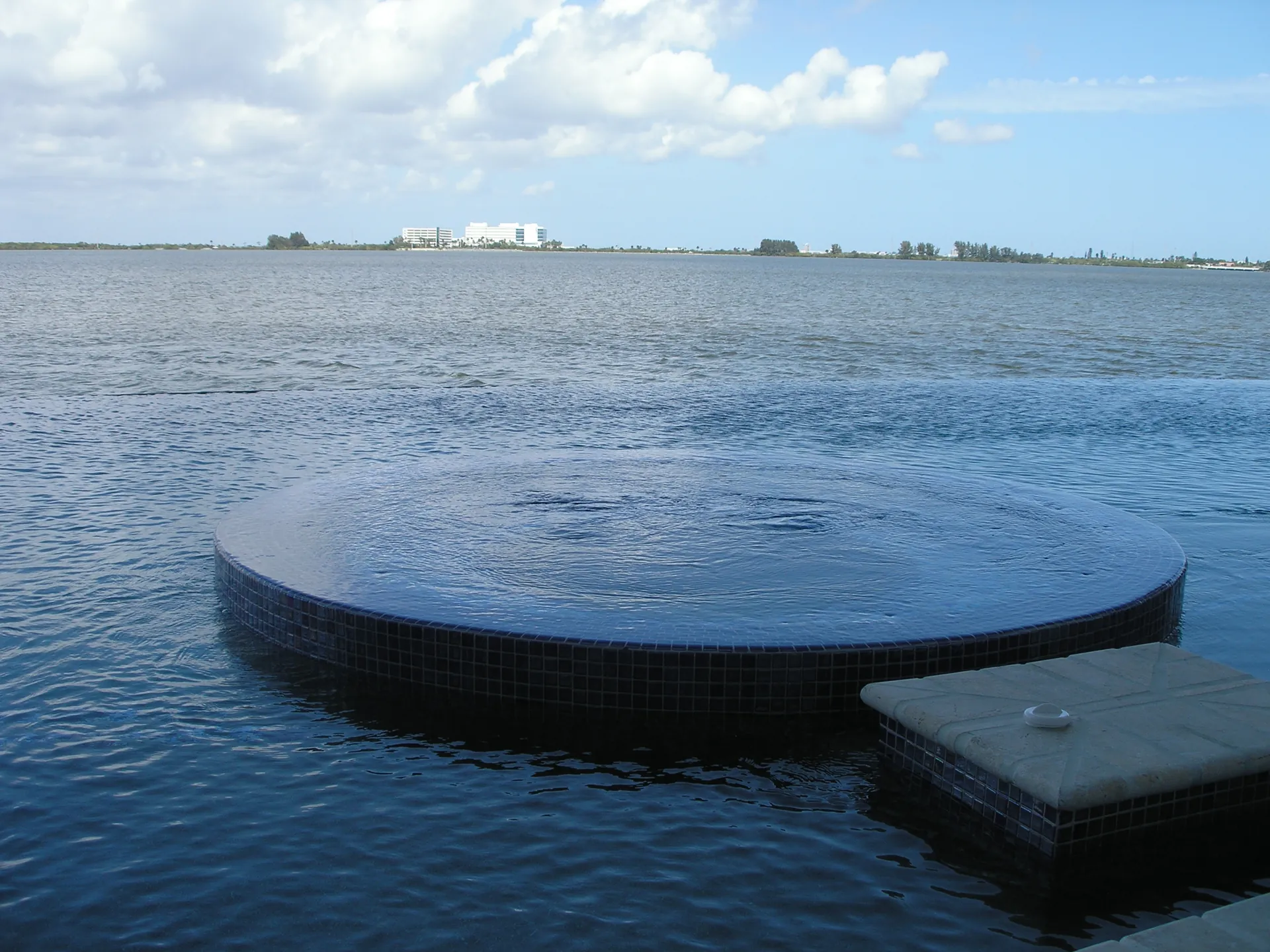 Perimeter overflow spa flush with an infinity pool over the Indian River lagoon
